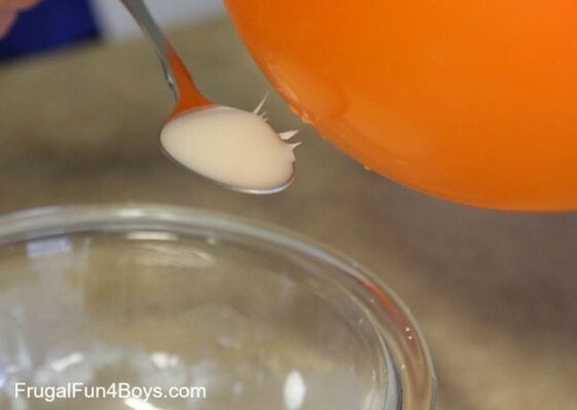 A mix of cornstarch and oil attracted to an orange balloon by static electricity