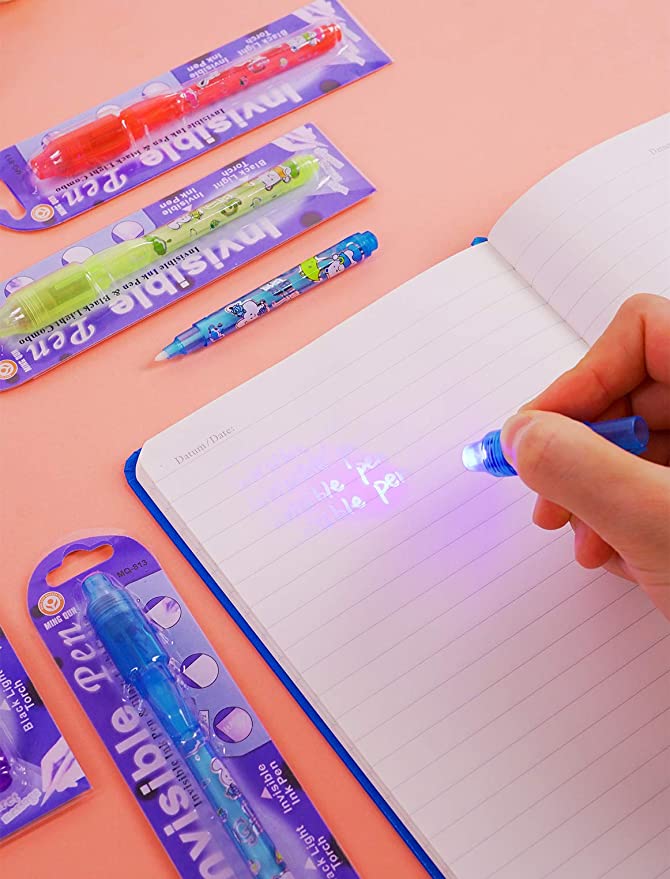Student writing in notebook with invisible ink pen