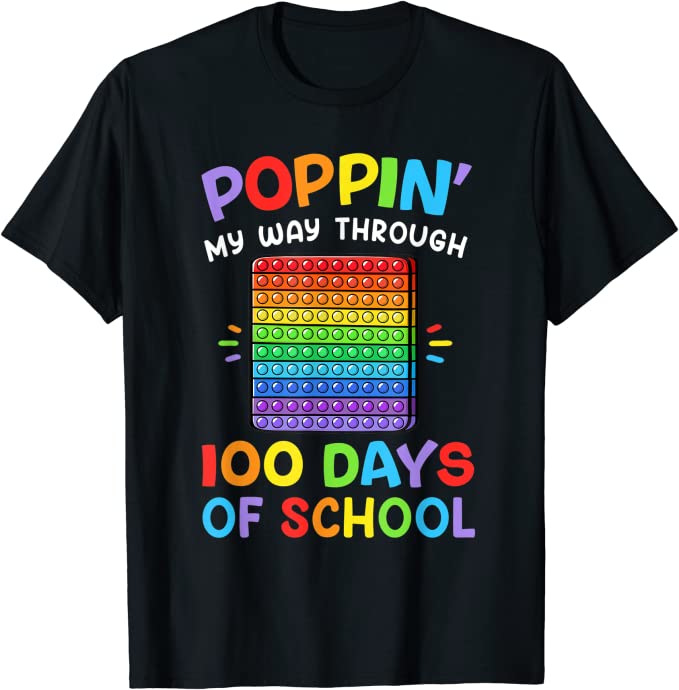 100th day of school shirt ideas include this black shirt that has a pop it fidget toy in rainbow colors. It says Poppin My Way Through 100 Days of School also in rainbow. 