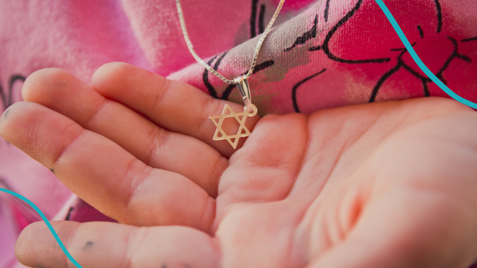 Photo of child holding Star of David necklace representing the rise of antisemitism in schools